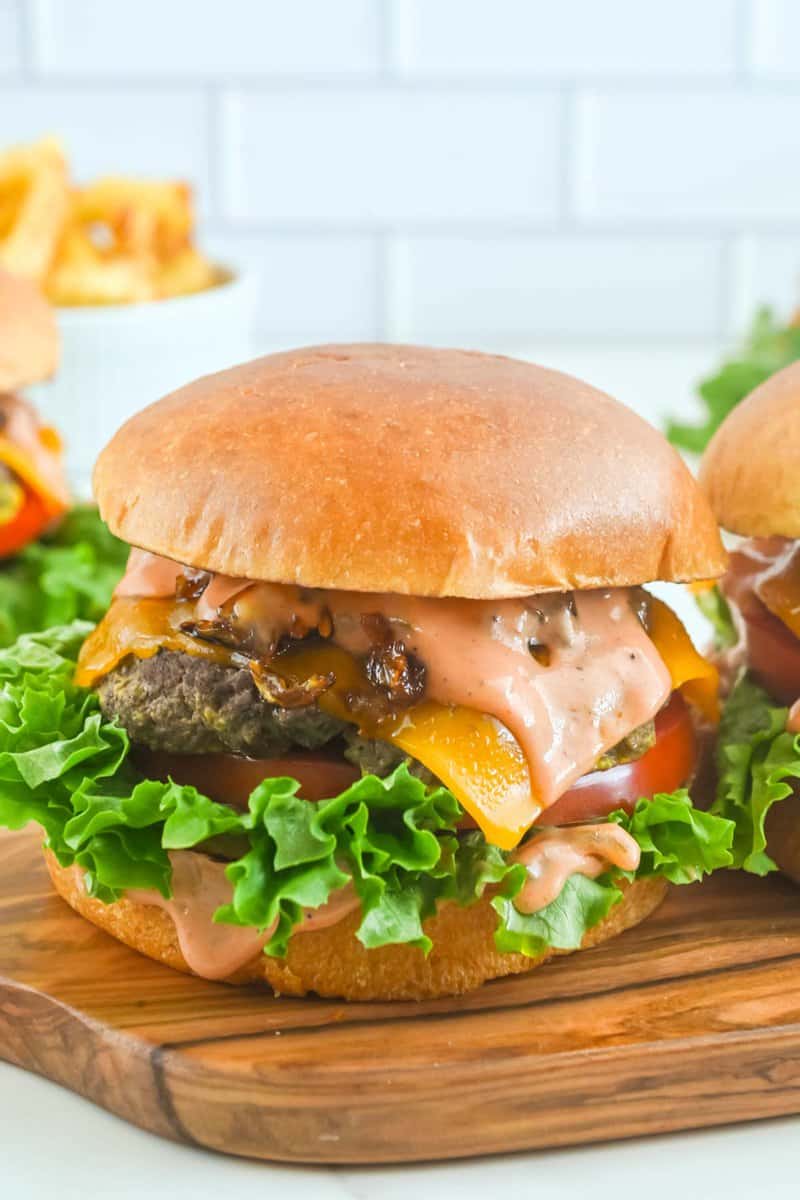 Copycat In-N-Out animal style burger on a small wood serving board.