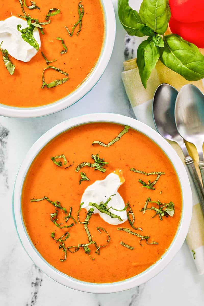 Copycat La Madeleine red pepper soup garnished with fresh basil.