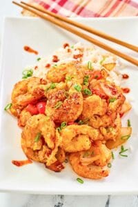 Copycat Panda Express chili crisp shrimp and white rice on a plate.