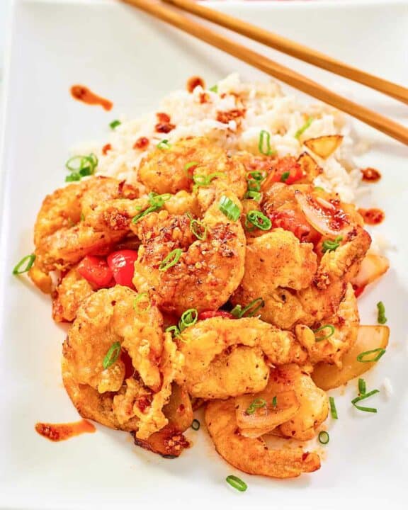 Copycat Panda Express chili crisp shrimp and white rice on a plate.