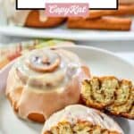 Two homemade Panera Bread cinnamon rolls on a plate and one cut in half.
