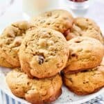 Copycat Panera kitchen sink cookies on a plate and a glass of milk behind it.