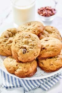 Copycat Panera kitchen sink cookies on a plate and a glass of milk behind it.