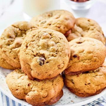 Copycat Panera kitchen sink cookies on a plate and a glass of milk behind it.