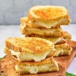 Homemade Starbucks grilled cheese sandwich halves on a wood board.