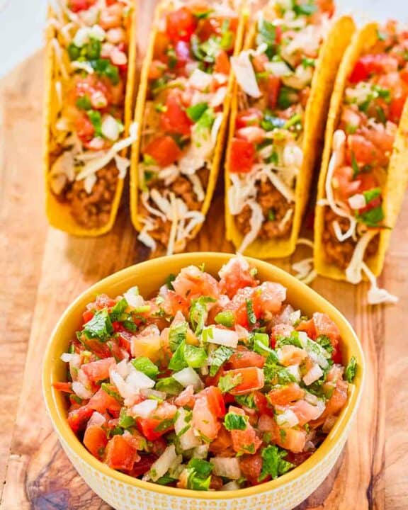A bowl of copycat Applebee's pico de gallo and four tacos.