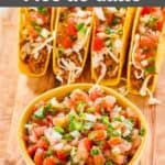 A bowl of homemade Applebee's pico de gallo in a bowl and tacos on a wood board.