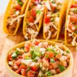 A bowl of homemade Applebee's pico de gallo and tacos behind it.