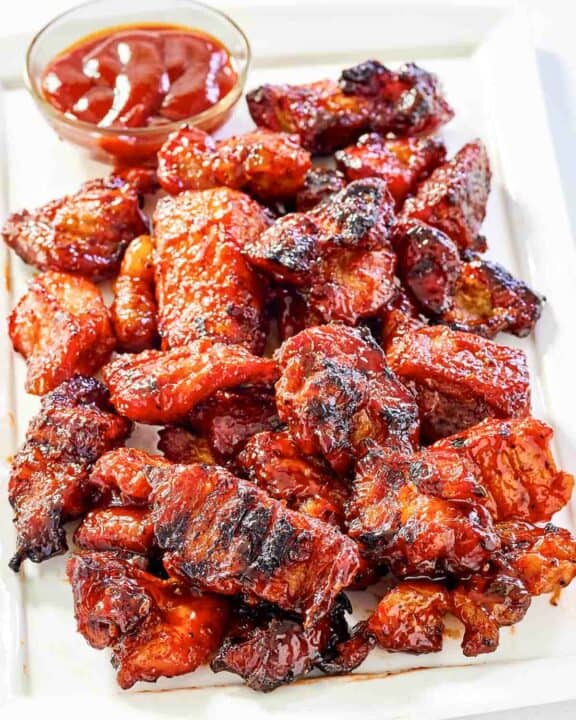 Copycat Applebee's riblets and a small cup of barbecue sauce on a platter.