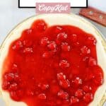 A whole cherry cream cheese pie and a pie server.