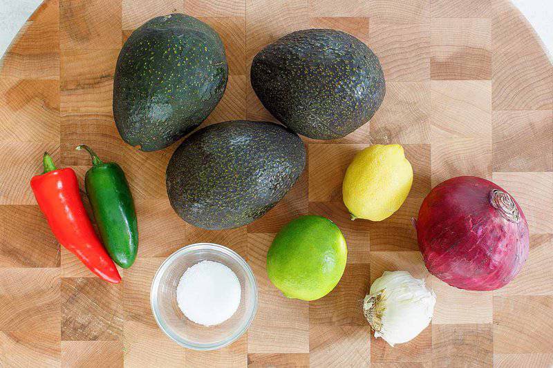 Copycat Chipotle guacamole ingredients on a wood board.