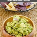 Homemade Chipotle guacamole and tortilla chips in a basket behind it.