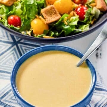 Copycat Outback honey mustard dressing in a bowl and a salad.