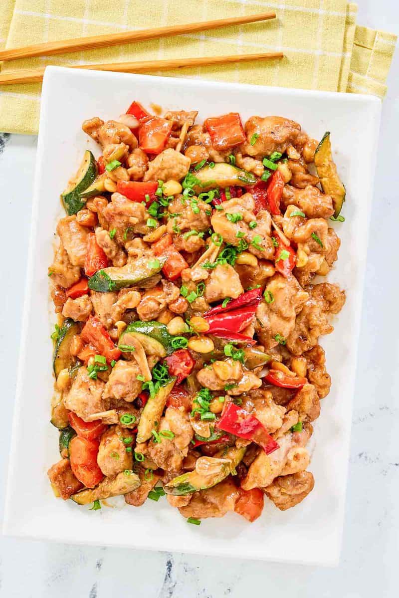 Copycat Panda Express kung pao chicken on a plate and chopsticks next to it.