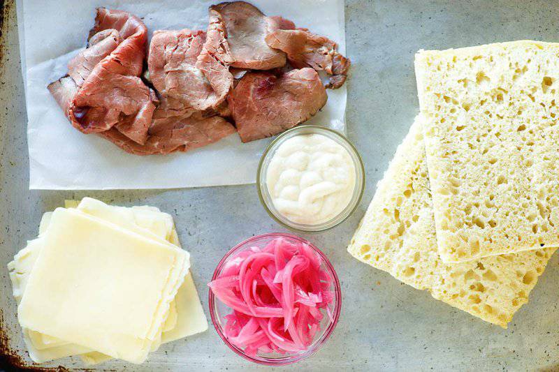 Copycat Panera steak and white cheddar panini ingredients on a marble surface.