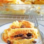 Homemade Raglan Road bread pudding with raisins and a fork on a plate.