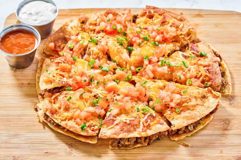 Copycat Taco Bell Mexican pizza served with taco sauce and sour cream.