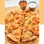 Homemade Taco Bell Mexican pizza sliced and on a wood serving board.