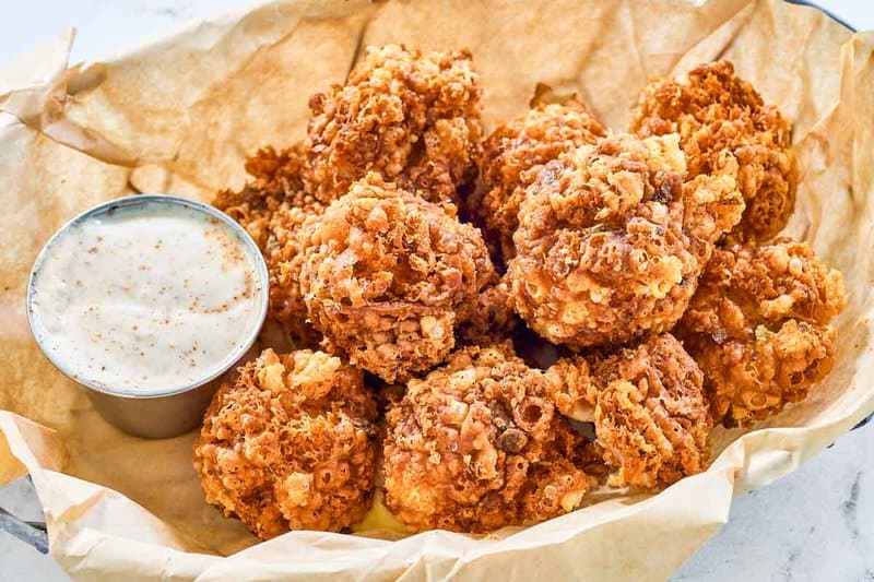 Copycat Texas Roadhouse rattlesnake bites with cajun sauce in a serving basket.