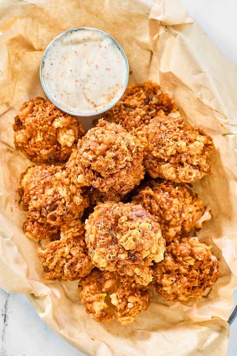 Copycat Texas Roadhouse rattlesnake bites and cajun dipping sauce in a serving basket.