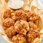 Copycat Texas Roadhouse rattlesnake bites and cajun sauce in a serving basket.