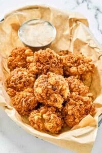 Copycat Texas Roadhouse rattlesnake bites and cajun sauce in a serving basket.