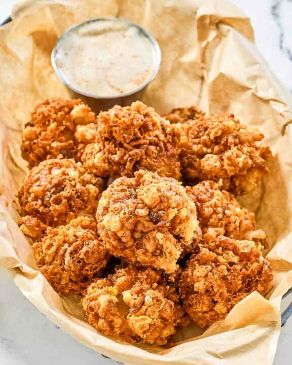 Copycat Texas Roadhouse rattlesnake bites and cajun sauce in a serving basket.