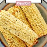 Four air fried corn cobs on a plate.