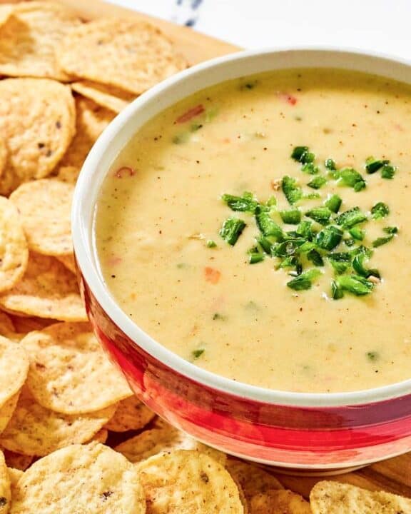 Copycat Chipotle queso blanco in a bowl and tortilla chips beside it.