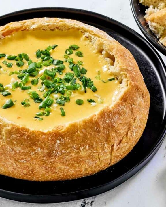 Copycat Red Lobster ultimate fondue in a bread bowl and some bread cubes by it.