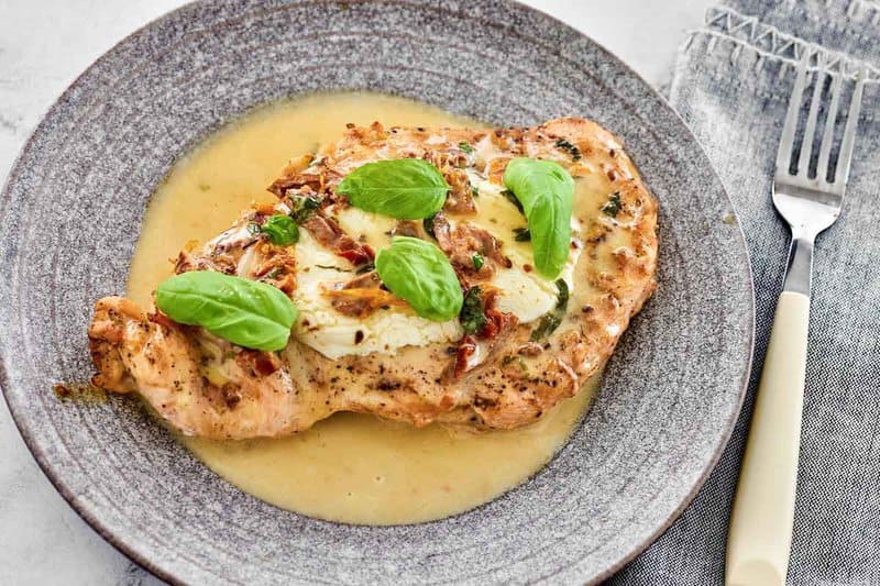 Copycat Carrabbas's chicken bryan on a plate and a fork next to it.
