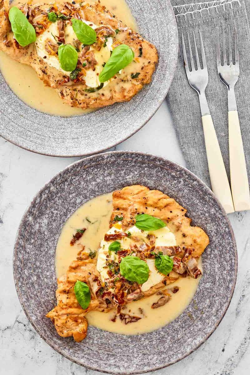 Copycat Carrabba's chicken bryan on two plates and two forks beside them.