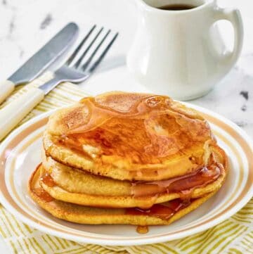 Copycat McDonald's pancakes with buttery maple syrup on a plate.
