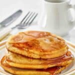 Homemade McDonald's pancakes topped with buttery maple syrup on a plate.