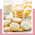 Copycat Panera lemon drop cookies piled on a plate and a glass of milk beside it.