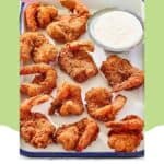 Copycat red lobster coconut shrimp and a bowl of dipping sauce on a serving tray.