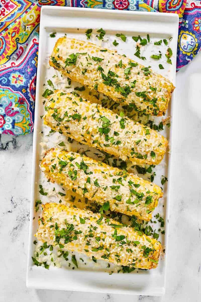 Four ears of copycat Chili's roasted street corn on a platter.