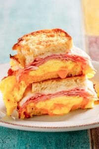 Copycat Denny's moons over my hammy breakfast sandwich halves stacked on a plate.