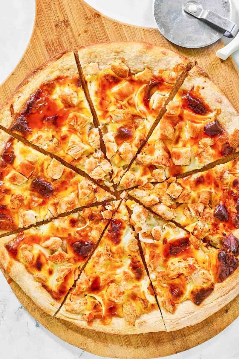 Sliced copycat Domino's Buffalo chicken pizza on a pizza peel.