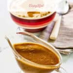 Copycat KFC gravy in a glass gravy boat and on mashed potatoes.