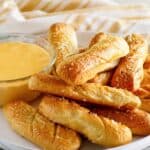 Copycat TGI Friday's soft pretzel sticks and beer cheese dip on a plate.