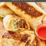 Homemade Taco Bell quesaritos and taco sauce on a wood board.