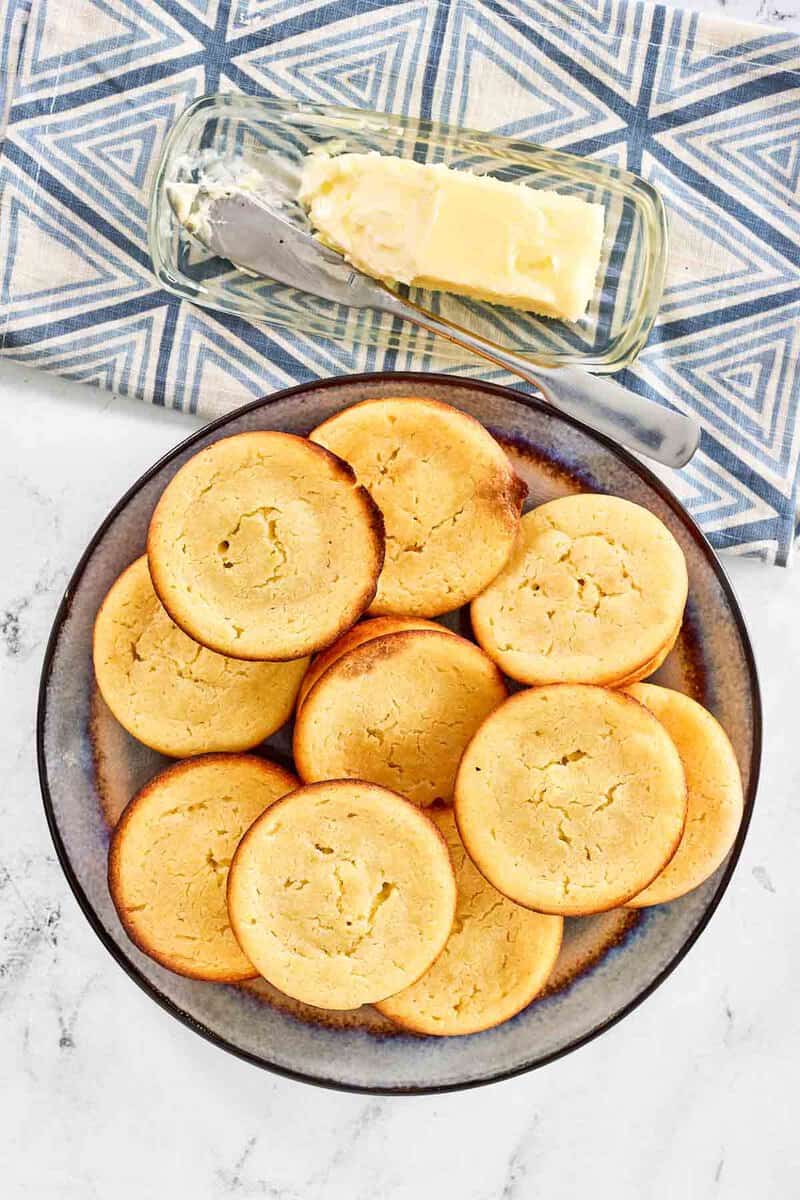 Copycat Cracker Barrel cornbread muffins on a plate and a butter on a butter dish.