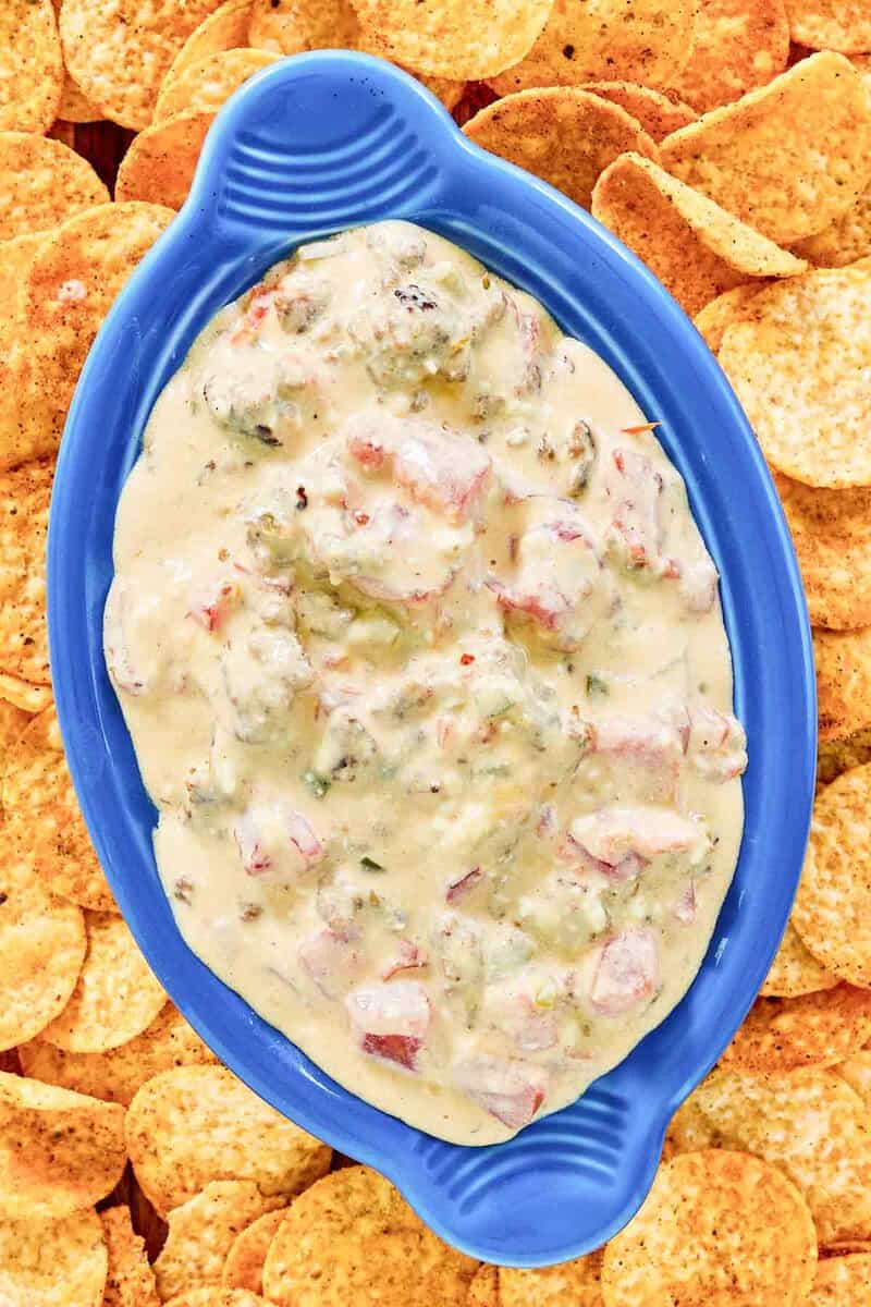 Rotel sausage cream cheese dip and tortilla chips around it.