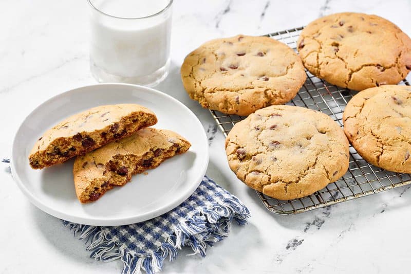 Copycat Crumbl chocolate chip cookies on a plate and wire rack.