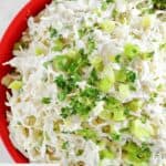 A bowl of homemade Houston's coleslaw garnished with parsley and green onions.