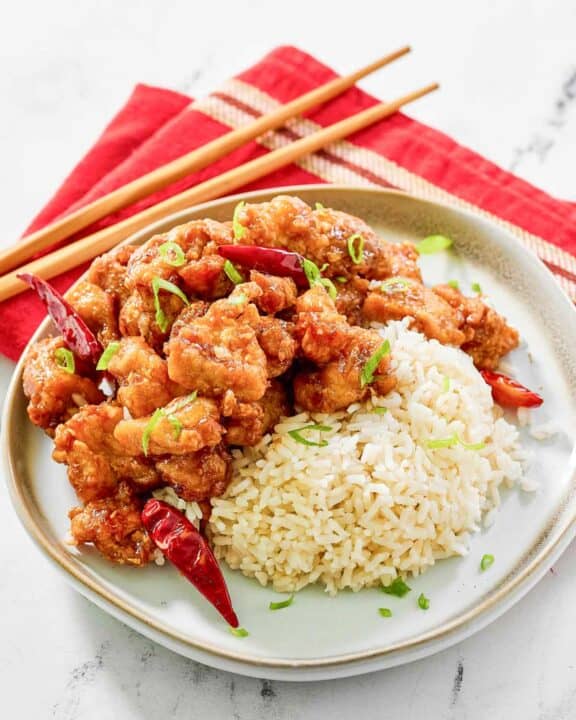 Copycat Panda Express hot orange chicken and rice on a plate.