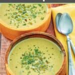 Acorn squash soup in two bowls and two spoons on top of a cloth napkin.