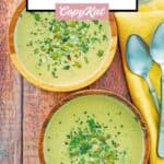Bowls of acorn squash soup and spoons next to them.