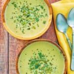 Acorn squash soup in two wood bowls and two spoons.